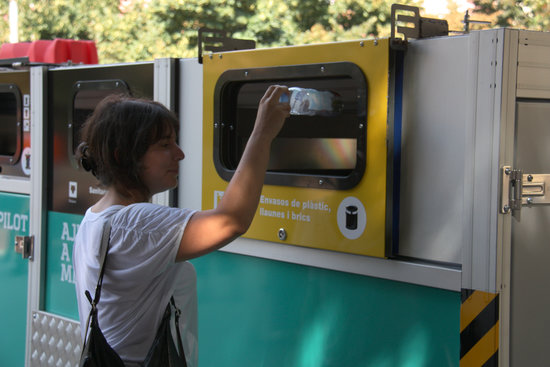 A woman recycling a plastic bottle in Barcelona's Bon Pastor neighborhood (by Ariadna Coma)